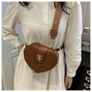 Detailed shot of brown heart-shaped bag with diamond quilting and gold rotating lock
