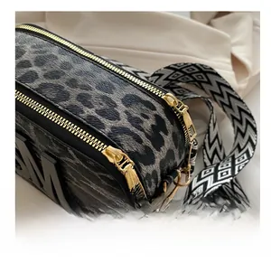 Detailed close-up of smooth dual golden zippers and leopard print textured fabric