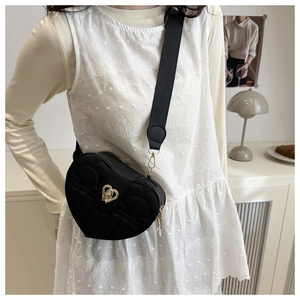Detail of black heart crossbody bag with lychee grain texture and metal swivel lock