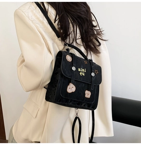 Detail showing black waterproof backpack with sequin bear patches and yellow embroidery