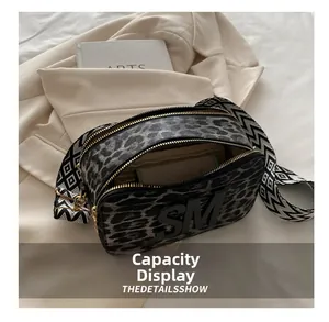 Interior view showing capacity of leopard print camera bag with wide jacquard strap