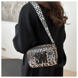 Detail of leopard print camera bag with black SM logo and patterned woven strap
