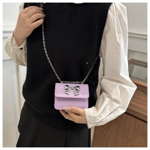 Mini purple crossbody bag with silver bow detail shown on model for daily style