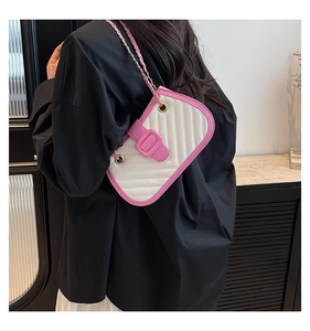 Détail de la bandoulière rose et du cuir blanc matelassé sur le sac à main
