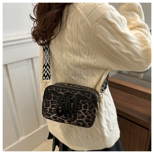 Detail of crossbody camera bag with leopard print, SM logo and geometric wide strap