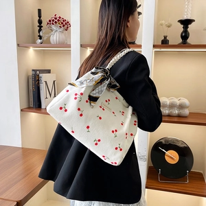 Large white corduroy tote bag with cherry print and silk scarf shown on model