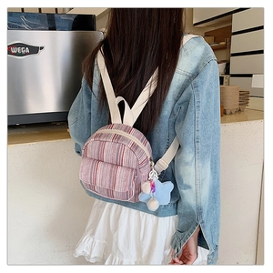 Detail of a mini striped canvas backpack with star charm and woven straps