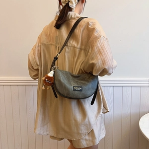 Minimalist large crescent crossbody bag in dark grey-green with a cute plush pendant
