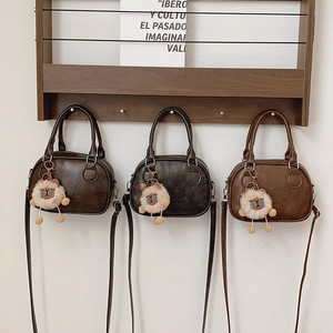 Trois sacs bandoulière minimalistes en cuir en forme de coquille avec breloques d'agneau mignon