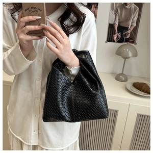 Detailed close-up of premium woven black PU leather texture on a minimalist bucket bag