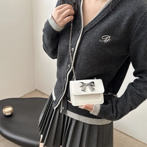 Mini white patent leather chain crossbody bag with a silver metal bow accent