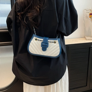 Contrast color quilted crossbody bag with chain strap shown on model's shoulder