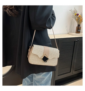 Vue détaillée d'un sac bandoulière beige tissé avec lanière en cuir et boucle