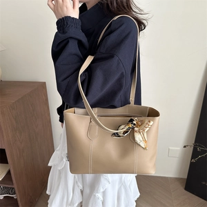 Minimalist khaki soft leather tote bag with contrast stitching and decorative scarf