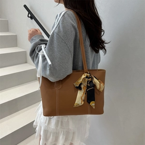 Brown soft leather tote bag with white contrast stitching and printed silk scarf