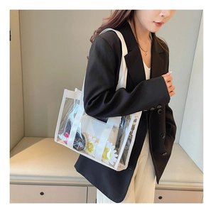 Detailed shot of transparent PVC tote bag with white canvas trim on a model