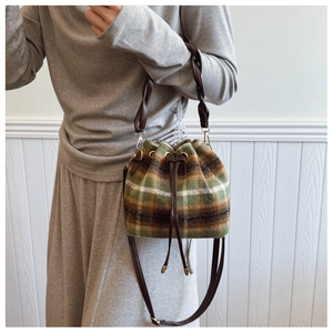 Detail of vintage plaid wool bucket bag with woven handle and drawstring closure