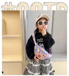 Detailed view of kids purple cartoon bear chest bag worn by model in warm indoor setting