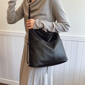 Minimalist black large capacity tote bag with lychee texture pattern on a female model