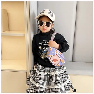 Detail of purple cartoon chest bag with cute pig prints on child's trendy fashion outfit