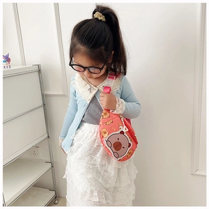 Detailed view of pink cartoon bear crossbody bag worn by a toddler in minimalist setting