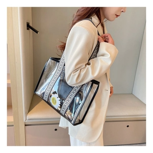 Detailed side view of clear PVC tote bag with stylish ethnic woven shoulder strap