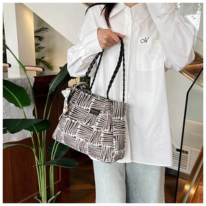 Detail of striped woven tote bag with elegant silk scarf and high-quality fabric texture