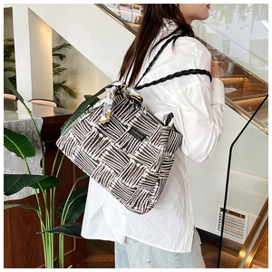 Detail of canvas tote bag with black and white stripes and floral silk scarf accessory