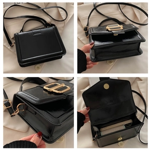 Detail of glossy black leather crossbody bag with elegant gold metal twist lock closure