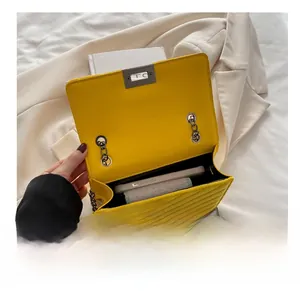 Top view of bright yellow quilted chain bag showing interior capacity with a phone