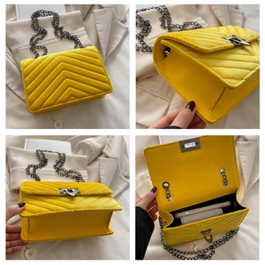 Detailed view of yellow quilted velvet chain bag with V-stitch texture and metal strap