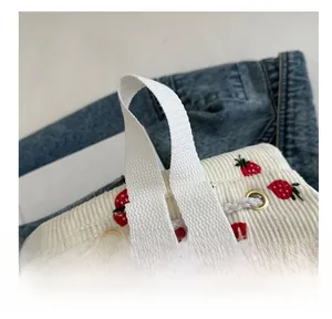 Detail of strawberry print corduroy drawstring bag with soft fabric handle