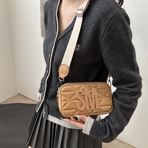 Brown quilted camera bag with SM metal logo and wide textile strap for women