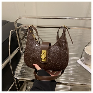 Detailed close-up of dark brown woven texture and gold metal buckle on hobo bag