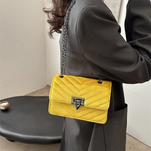 Yellow velvet crossbody bag with V-quilted stitching and black metal chain strap