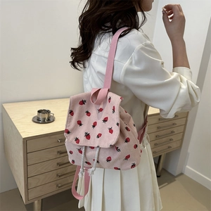 Pink corduroy backpack with red strawberry print and drawstring closure for women