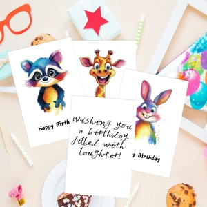Flat lay of watercolor animal birthday cards with cupcakes and party accessories