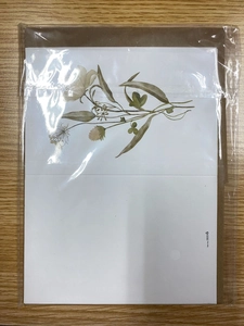 Detail of floral greeting card with botanical illustration in transparent packaging