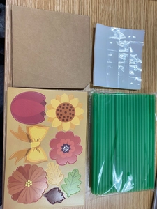 Flat lay of DIY flower bouquet card kit with brown kraft envelopes and floral stickers
