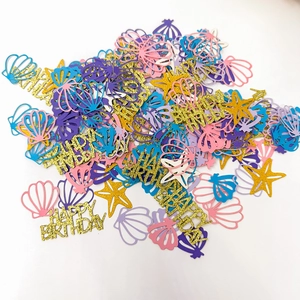 Macro view of ocean-themed birthday confetti with glitter starfish, shells and happy birthday text
