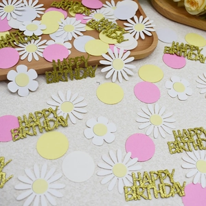 Close-up of pink and white daisy confetti with gold glitter Happy Birthday letters
