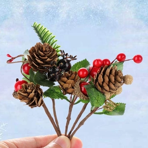Macro view of Christmas berry stems featuring natural pinecones and red holly berries