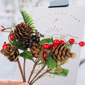 Detailed view of Christmas pine cones, red berries, and gold glitter ball floral picks