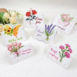 Detailed close-up of six assorted floral greeting cards with 3D die-cut designs on white fabric