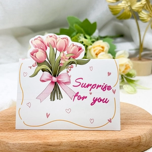 Detail of 3D bouquet card with pink tulips and Surprise for you text on wooden tray