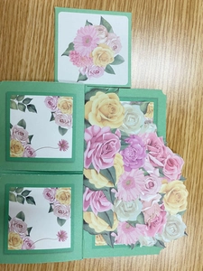 Macro detail of 3D pop-up flower cards with pink rose illustrations on wooden desk