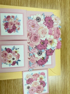 Detail of 3D pop-up greeting card featuring layers of floral bouquets and a gold envelope