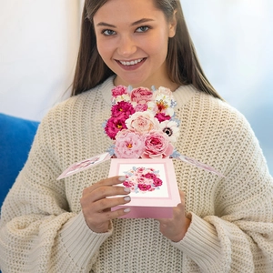 3D pop-up flower card held by a person showing intricate pink floral papercraft