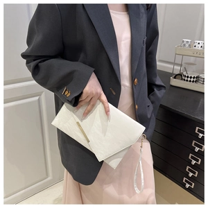 Détail de la pochette enveloppe blanche avec texture plissée et garniture dorée