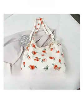 Close-up of floral tote bag fabric with rose print and a pearl bow charm detail